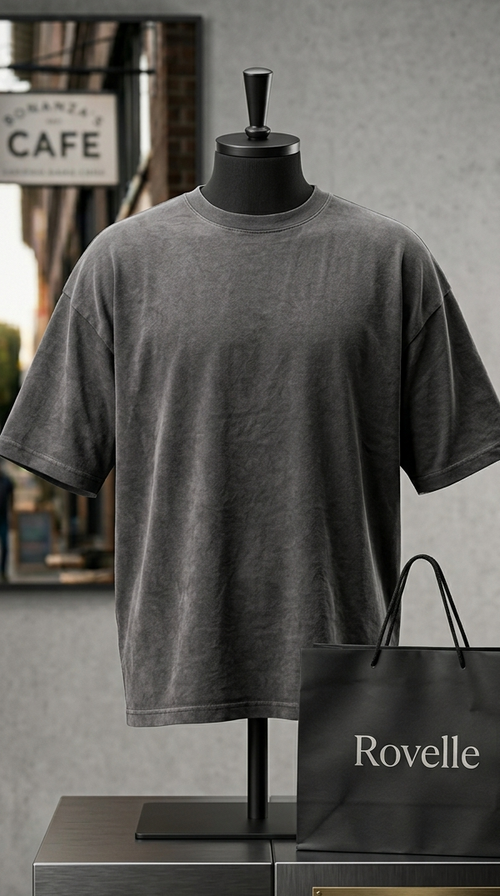 Gray t-shirt on a mannequin with a Rovelle shopping bag against a city street background