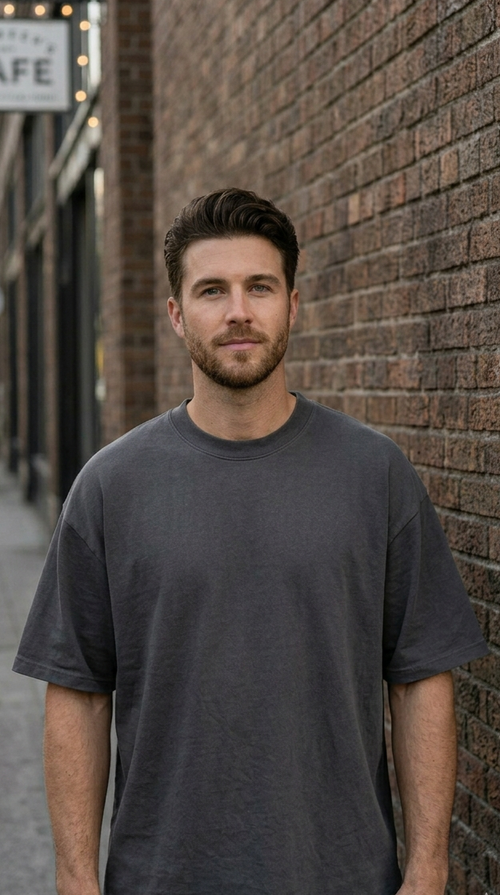 Man standing against a brick wall with a cafe sign in the background